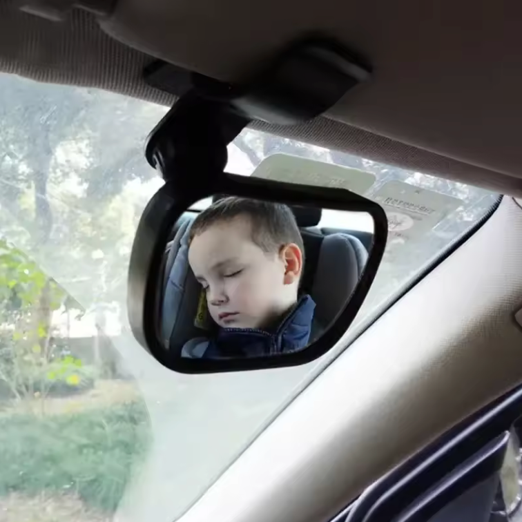 Child's reflection in a car mirror inside a vehicle