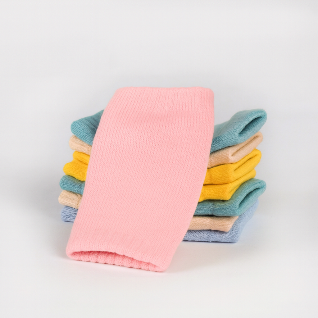 Stack of colorful folded socks on a light gray background
