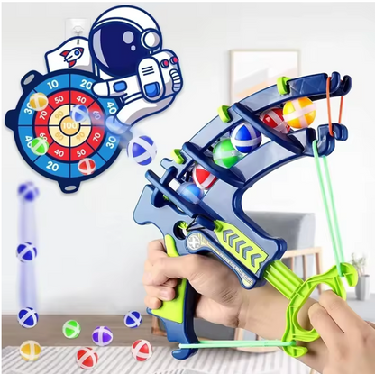 Toy slingshot with colorful balls and a target in the background